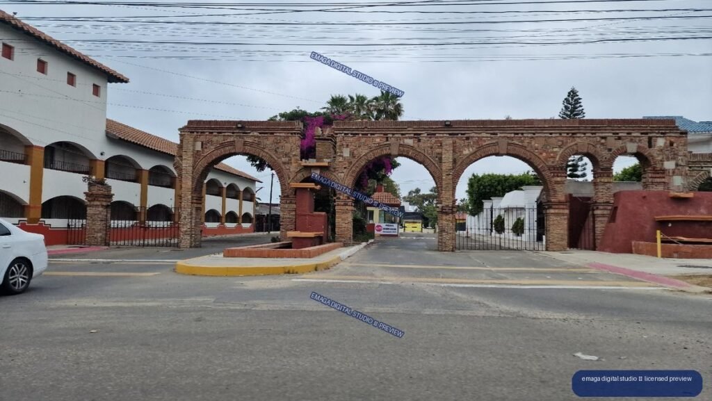 Brick Archway Entrance with Colonial-Style Buildings and Palm Trees — Tijuana, Mexico