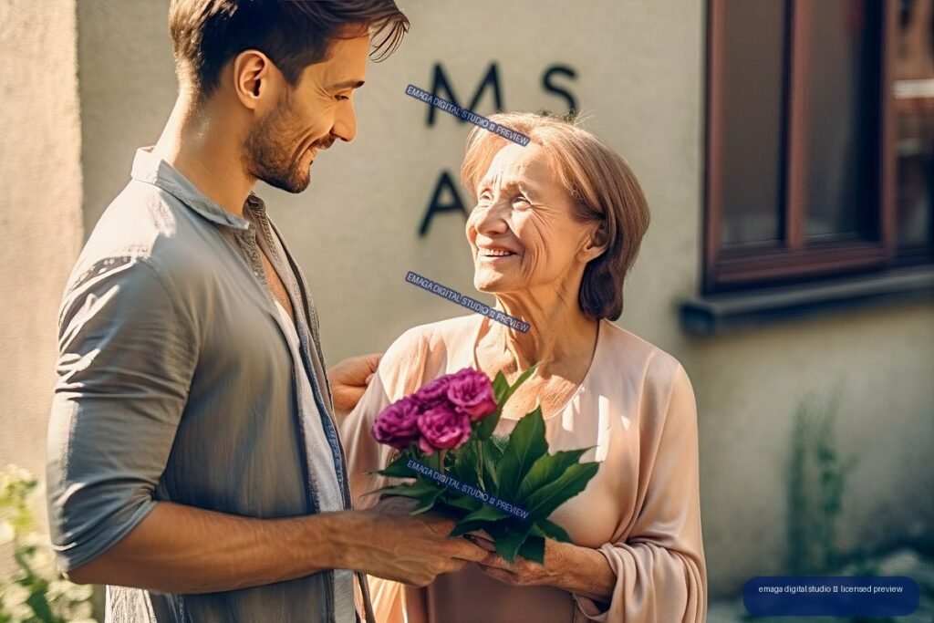 Smiling adult man gives purple flowers to an older woman outdoors in warm sunlight.