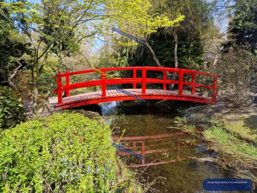 Red Japanese-Style Footbridge Over a Reflective Garden Pond — Hortulus Gardens, Dobrzyca