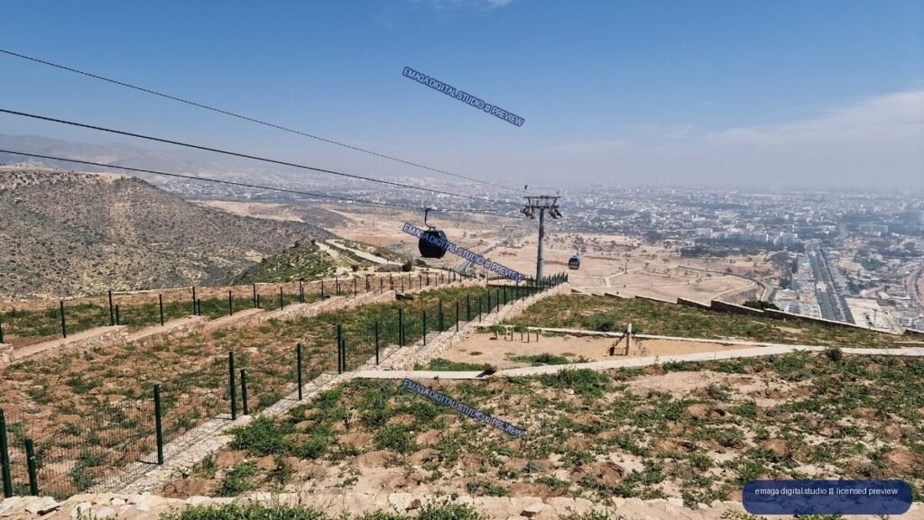 Cable car descending over a dry hillside and sprawling city