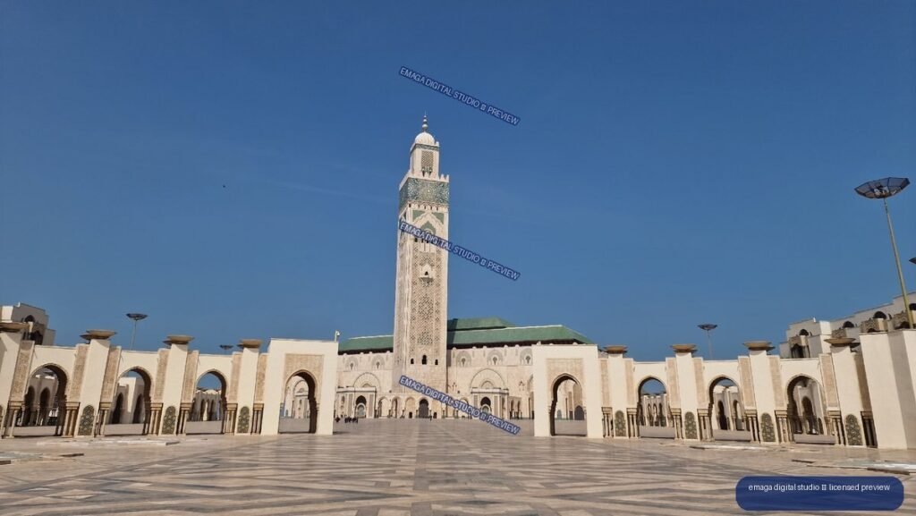 Hassan II Mosque courtyard with ornate minaret beneath blue sky — Casablanca, Morocco