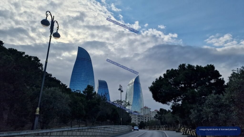 Curved glass towers above a tree-lined road in Baku, Azerbaijan