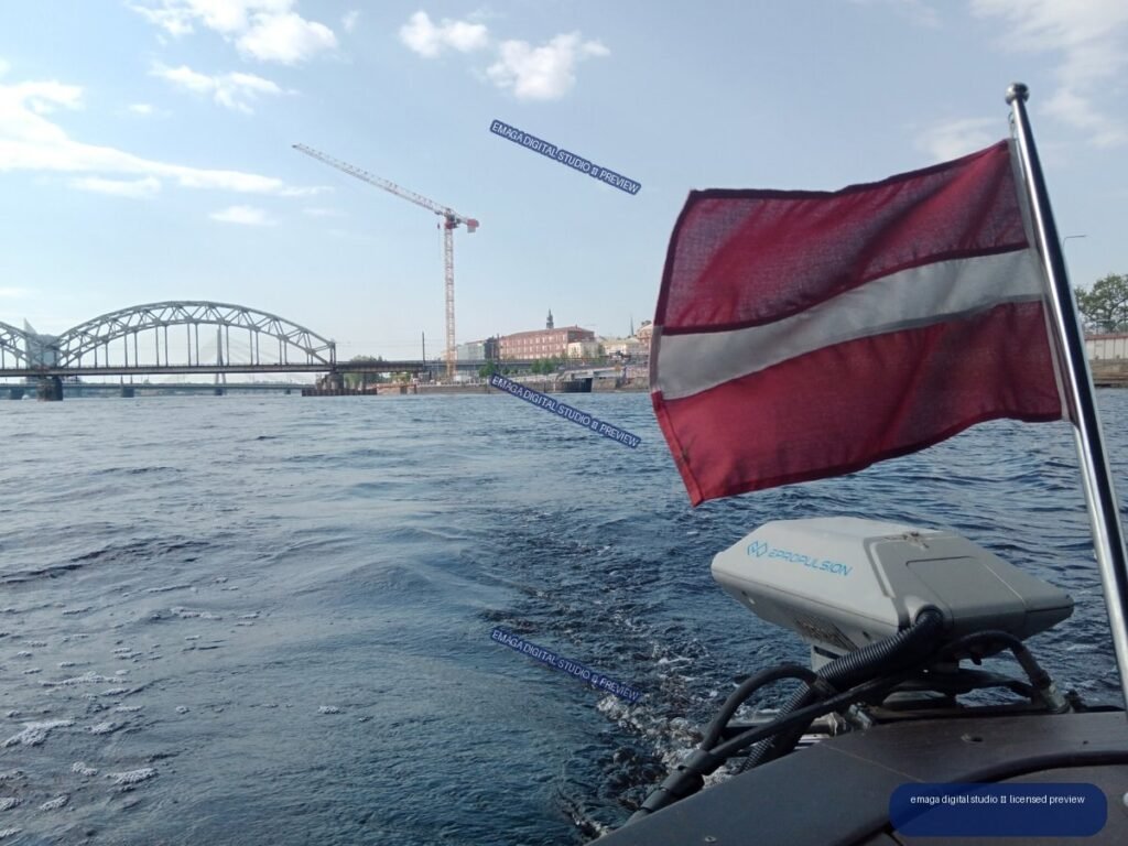 Latvian flag and river bridge viewed from a boat in Riga, Latvia