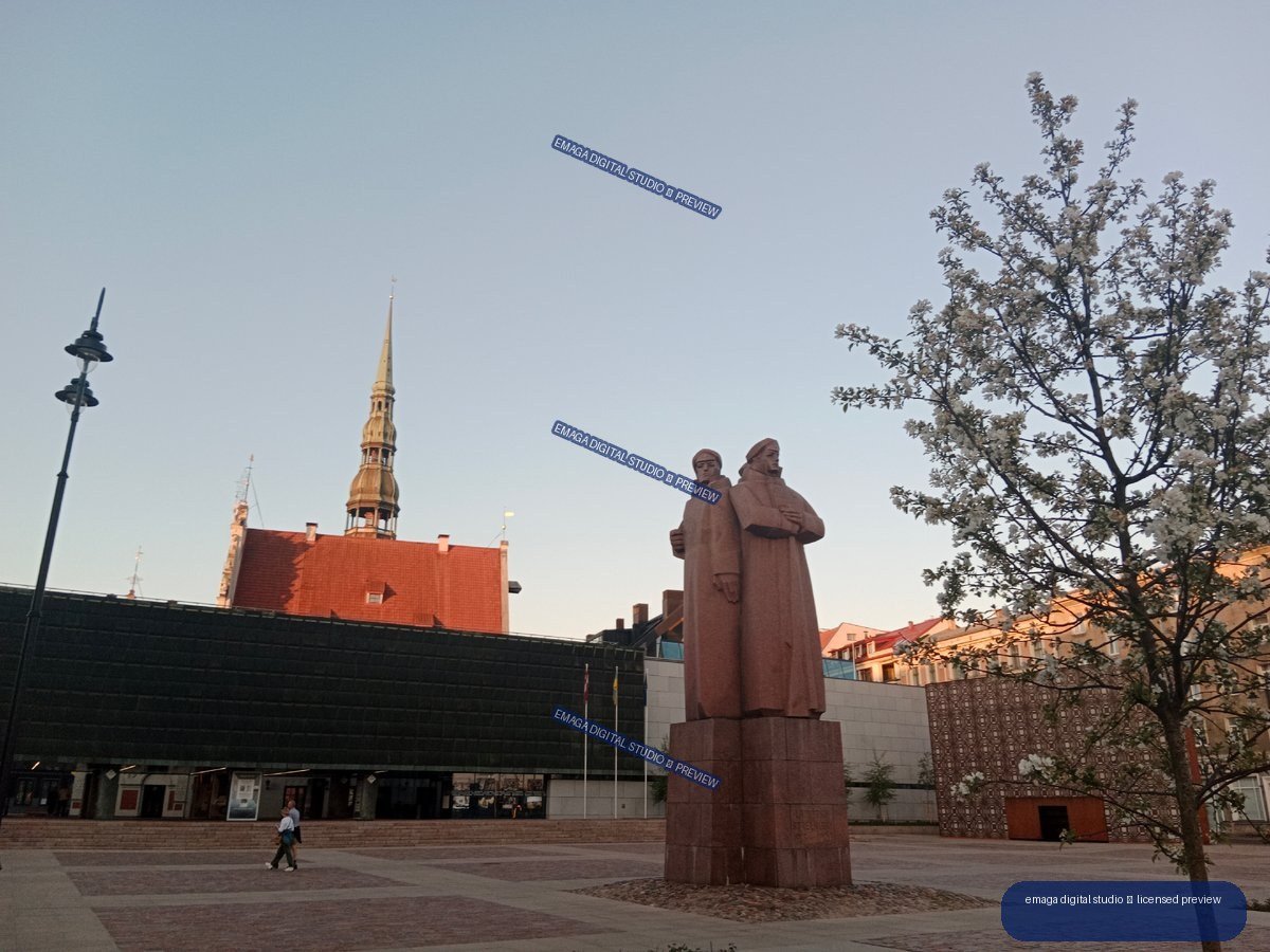 Urban square with monument and church tower in Riga, Latvia