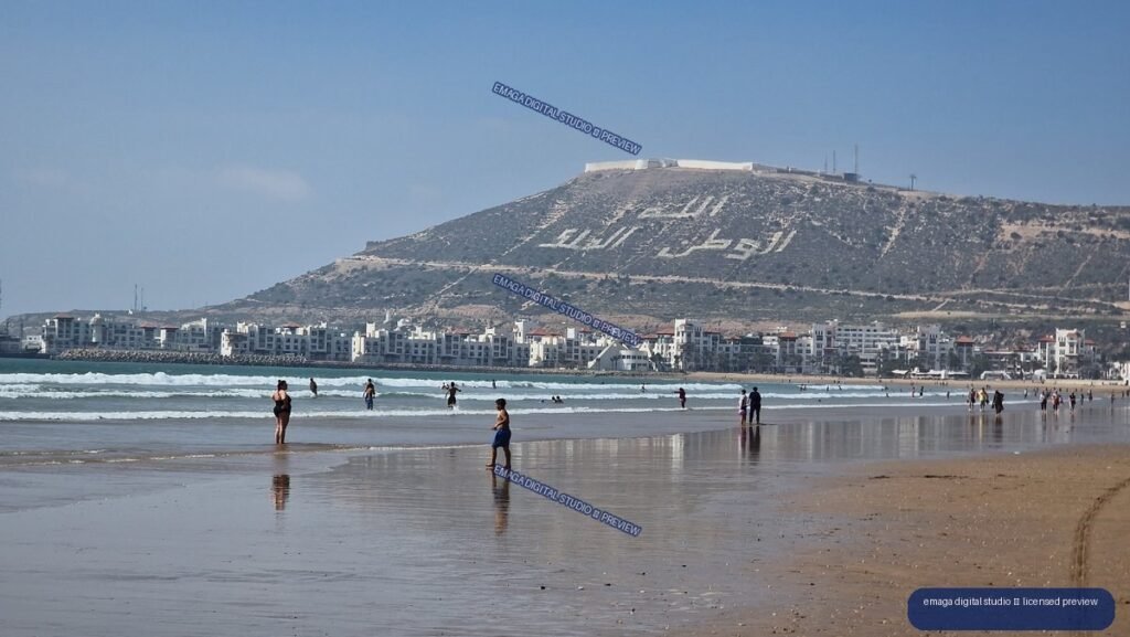Agadir Morocco beach with ocean waves and hillside cityscape