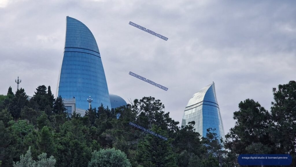 Curved glass towers above trees in Baku, Azerbaijan